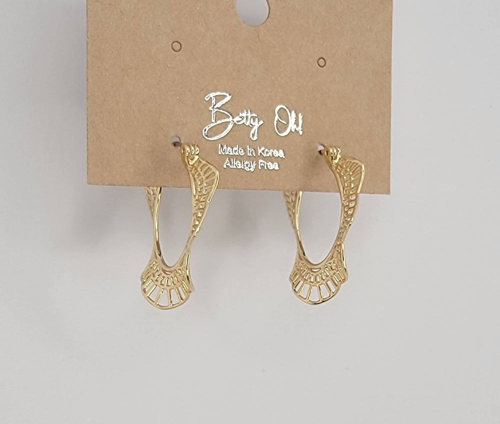 Gold earrings on a Betty Oh branded card against a light gray background