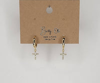 Gold cross earrings on a Betty Oh branded card against a light gray background