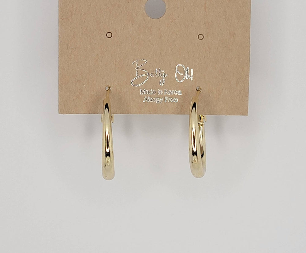 Gold hoop earrings on a Betty Oh! branded card against a light gray background