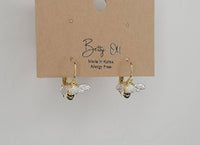 Bee-shaped earrings on a 'Betty Old' branded card against a light gray background