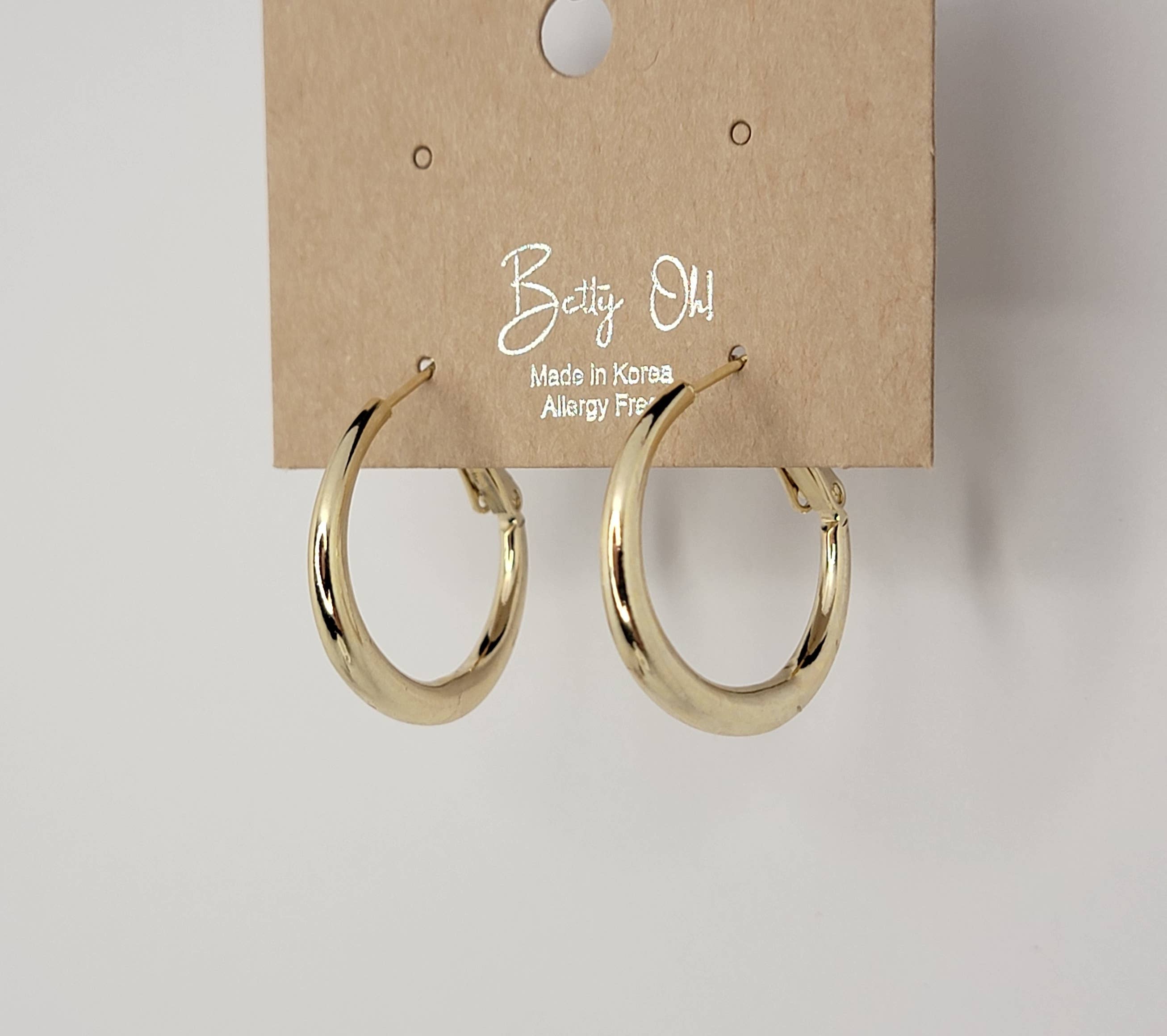 Gold hoop earrings on a 'Betty Oh!' branded card against a white background