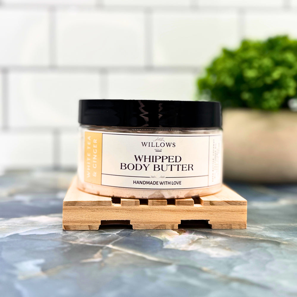 Jar of willows whipped body butter on a marble surface with a tiled wall background