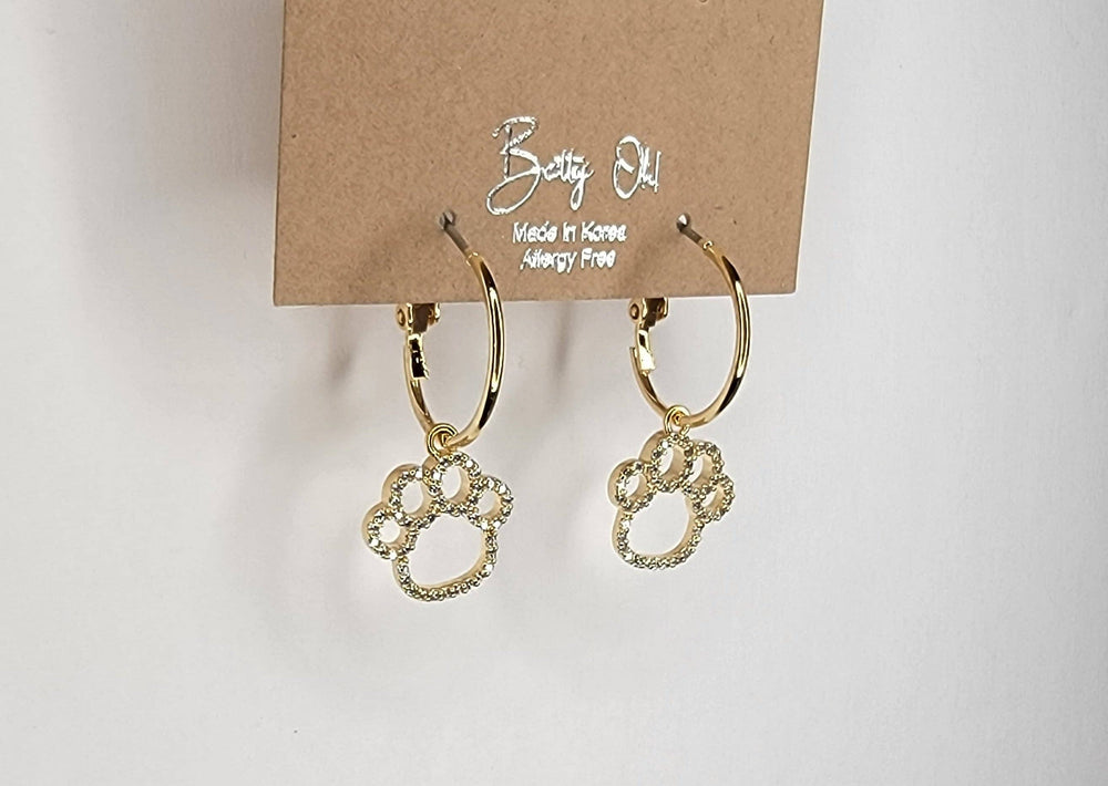 Gold hoop earrings on a cardboard backing with 'Betsy O.' branding.