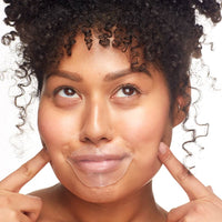 Woman pointing to her face with a gel lip mask on her lips on a white background