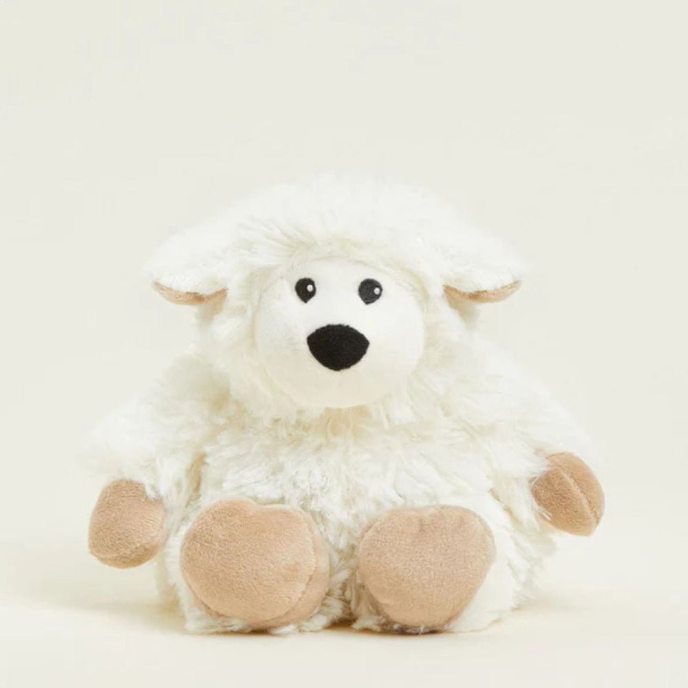 Plush sheep toy with white fur, black eyes, and brown paws on a light beige background